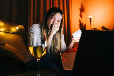 Woman with gift box looking at laptop