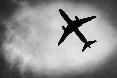 Low angle view of airplane flying against sky