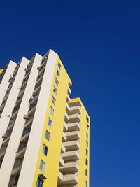 Low angle view of modern building against clear blue sky