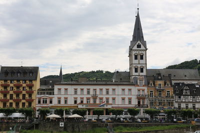 View of buildings in city against cloudy sky