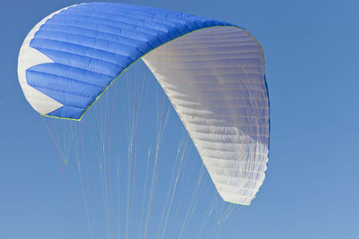 Low angle view of kite flying against blue sky