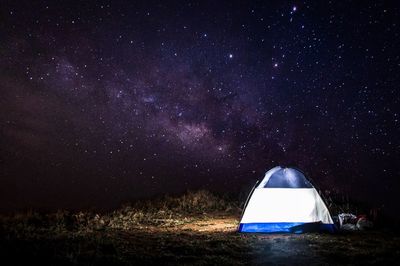 Illuminated tent against sky at night