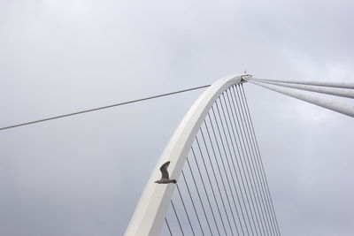 Low angle view of suspension bridge against sky