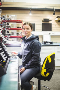 Portrait of mature technician working in electronics store