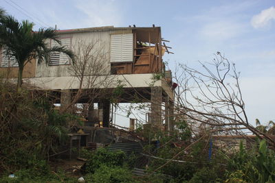 Abandoned house on field against sky