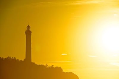 Silhouette of lighthouse against sky during sunset