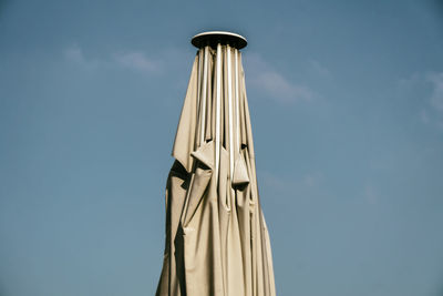 Low angle view of closed parasol against sky during summer