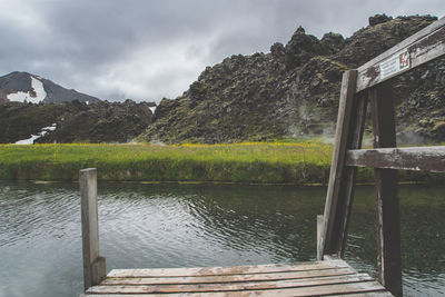 Scenic view of lake by mountains against sky