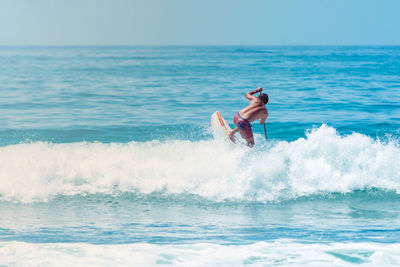 Man surfing in sea against sky
