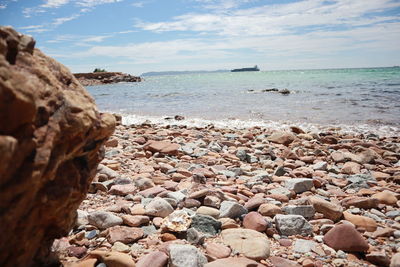 Rocks on beach against sky