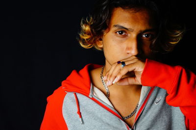 Portrait of young man against black background