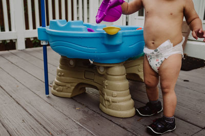 Baby playing with water toys in diaper