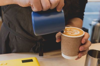 Midsection of woman holding coffee cup