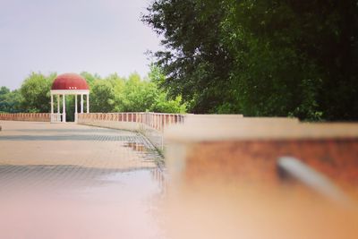 View of swimming pool by building against clear sky