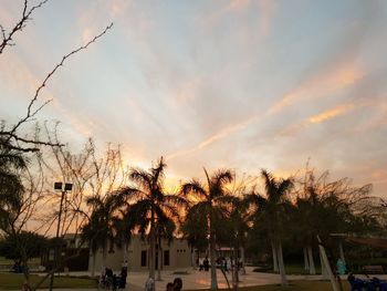 People in park against sky during sunset