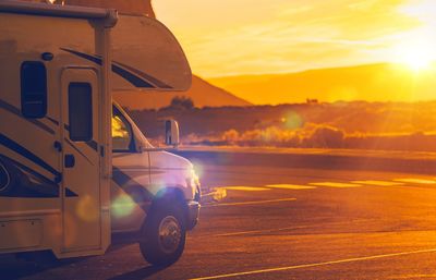 Travel trailer on road during sunset