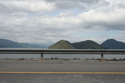 Road by mountains against sky