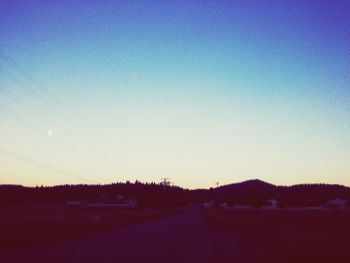 Empty road against clear blue sky