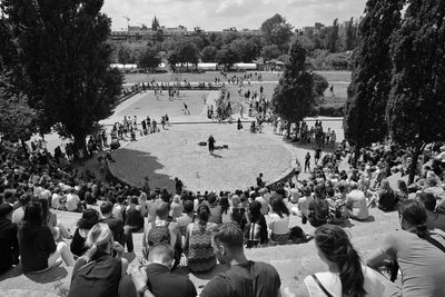 High angle view of spectators looking at man performing in park