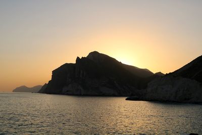 Scenic view of sea and mountains against sky during sunset