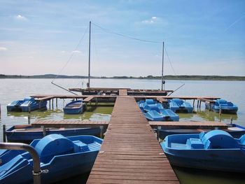 Sailboats moored in sea against sky