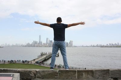 Rear view of man standing on bridge against sky