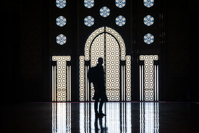 Full length of silhouette person standing in front of building