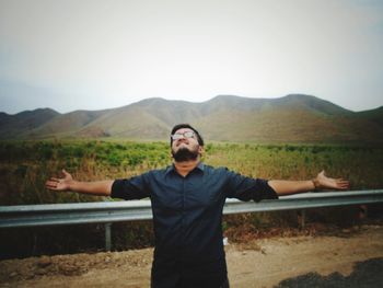 Young man standing in front of mountains