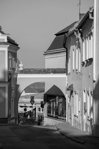 Empty road by buildings against clear sky