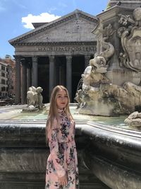 Statue of woman standing against fountain