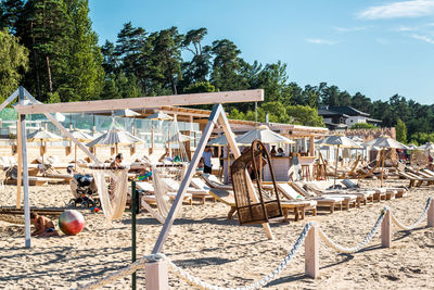 Deck chairs on beach against sky