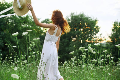 Woman standing on white flowering plants