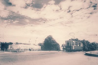 Building by street against sky in city during winter