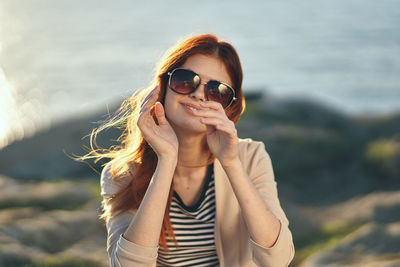 Portrait of woman wearing sunglasses standing outdoors
