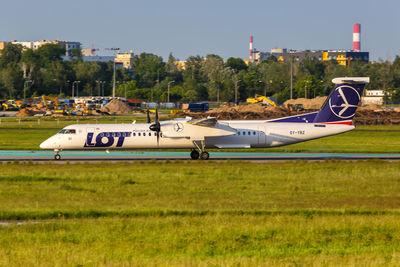 Side view of airplane on runway against sky