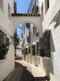 Walkway amidst buildings against sky