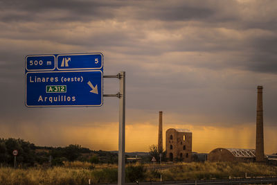 Road sign against sky during sunset