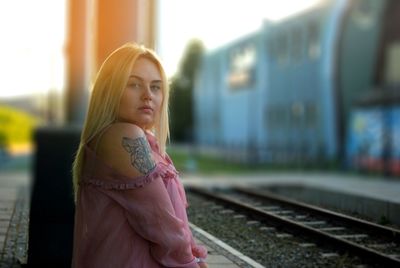 Side view portrait of young woman at railroad station