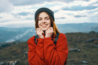 Portrait of smiling young woman standing against snow