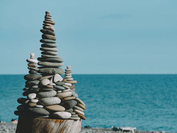 Stack of pebbles on beach against clear sky