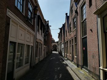 Narrow street amidst buildings against sky