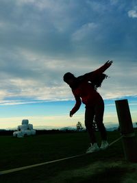 Man playing soccer ball on field against sky during sunset