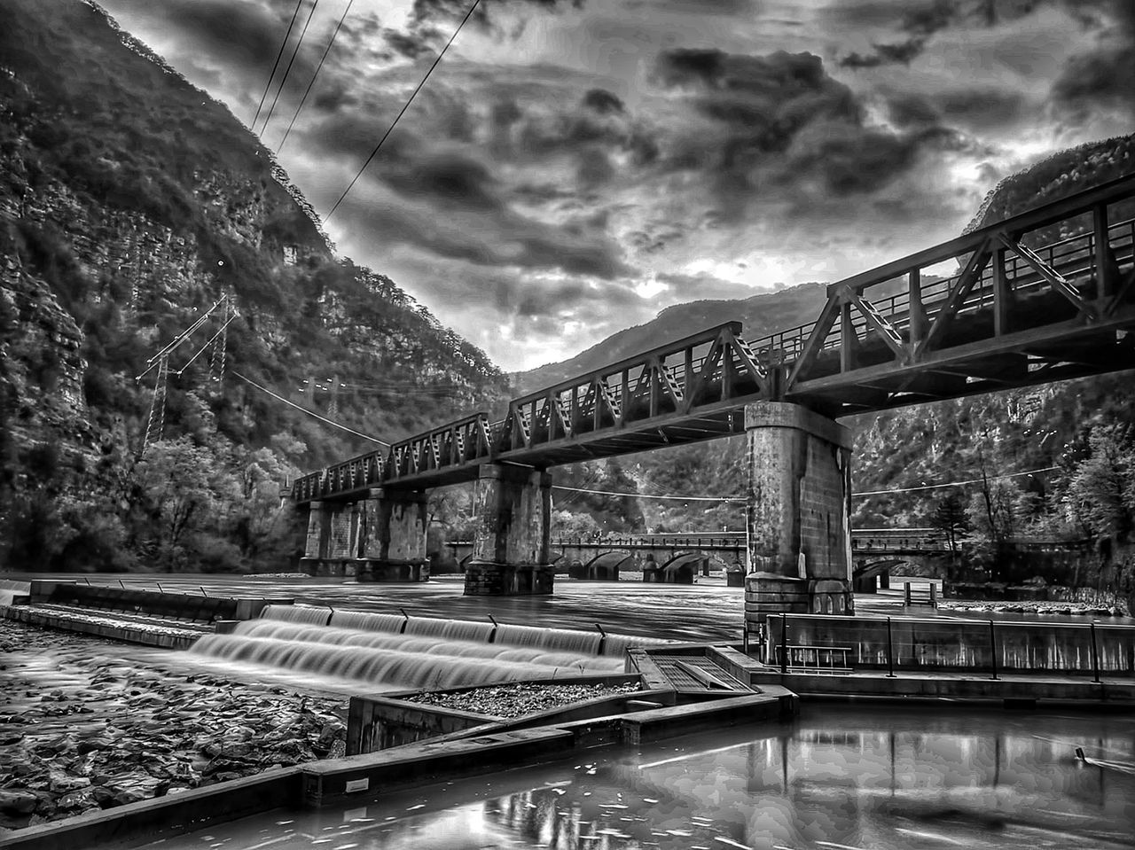 cloud, architecture, black and white, water, built structure, bridge, monochrome, sky, monochrome photography, nature, reflection, transportation, cityscape, no people, rail transportation, tree, river, travel destinations, plant, darkness, transport, outdoors, travel, building exterior, urban area, city, beauty in nature, mountain, scenics - nature, day