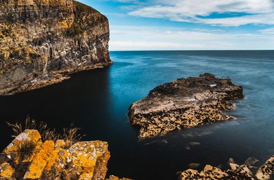 Scenic view of rocks in sea against sky