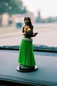 Close-up of female figurine on car dashboard