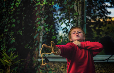 Boy playing with slingshot in yard