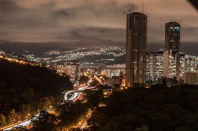 Illuminated cityscape against sky at night