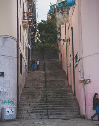 Walkway amidst buildings against sky
