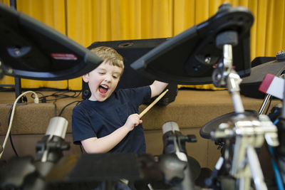 Playful boy playing drum kit at grace baptist church