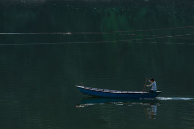 Man in boat sailing on lake